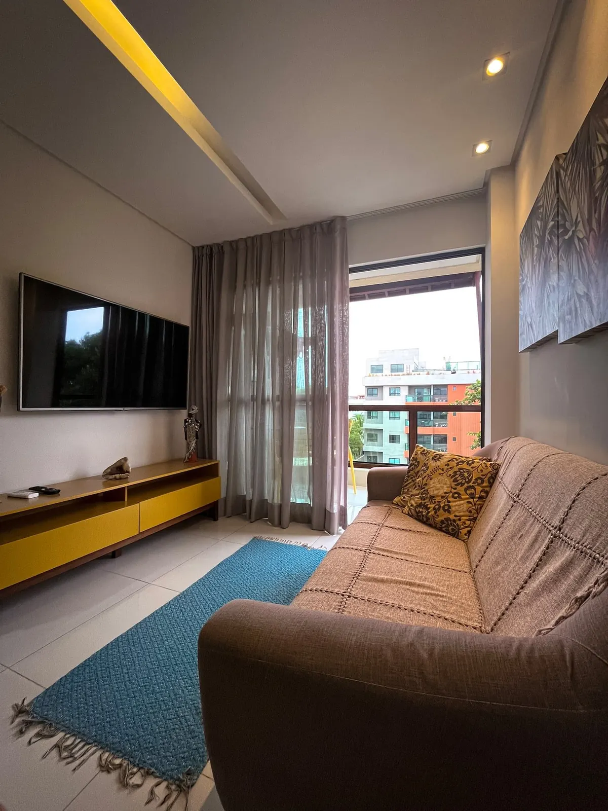 A sala climatizada, com TV de 65 polegadas