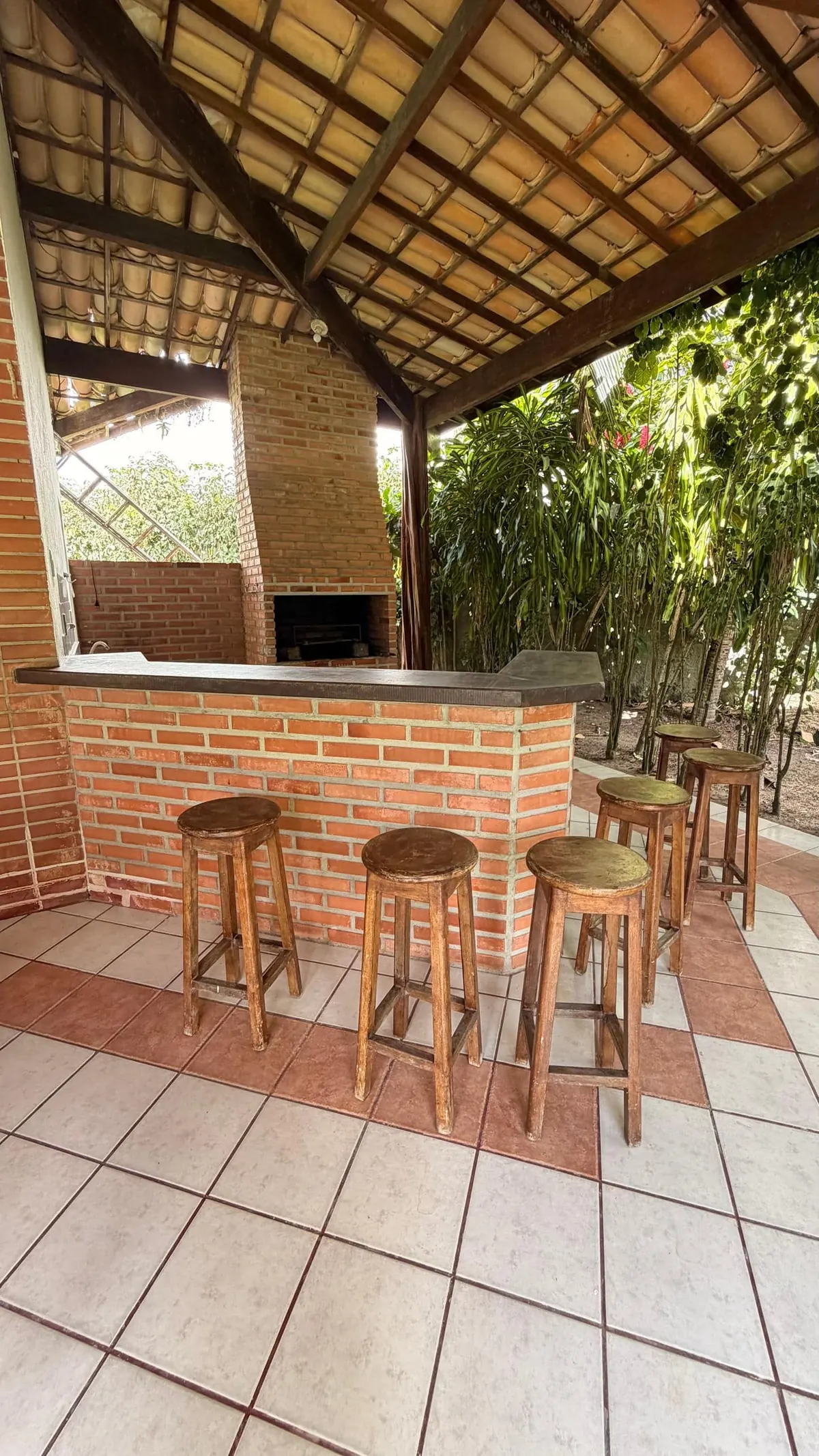 O bar com banquetas e a churrasqueira