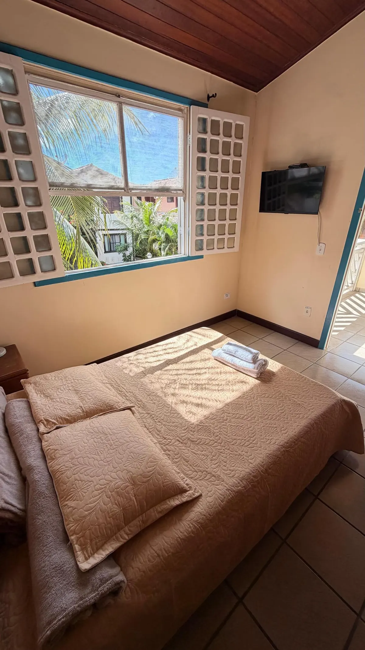 Quarto com janela para os coqueiros